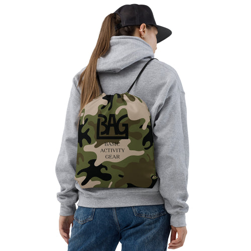 Person wearing a camouflage drawstring bag with B,A,G Logo combined with 'Basic Activity Gear' text on it