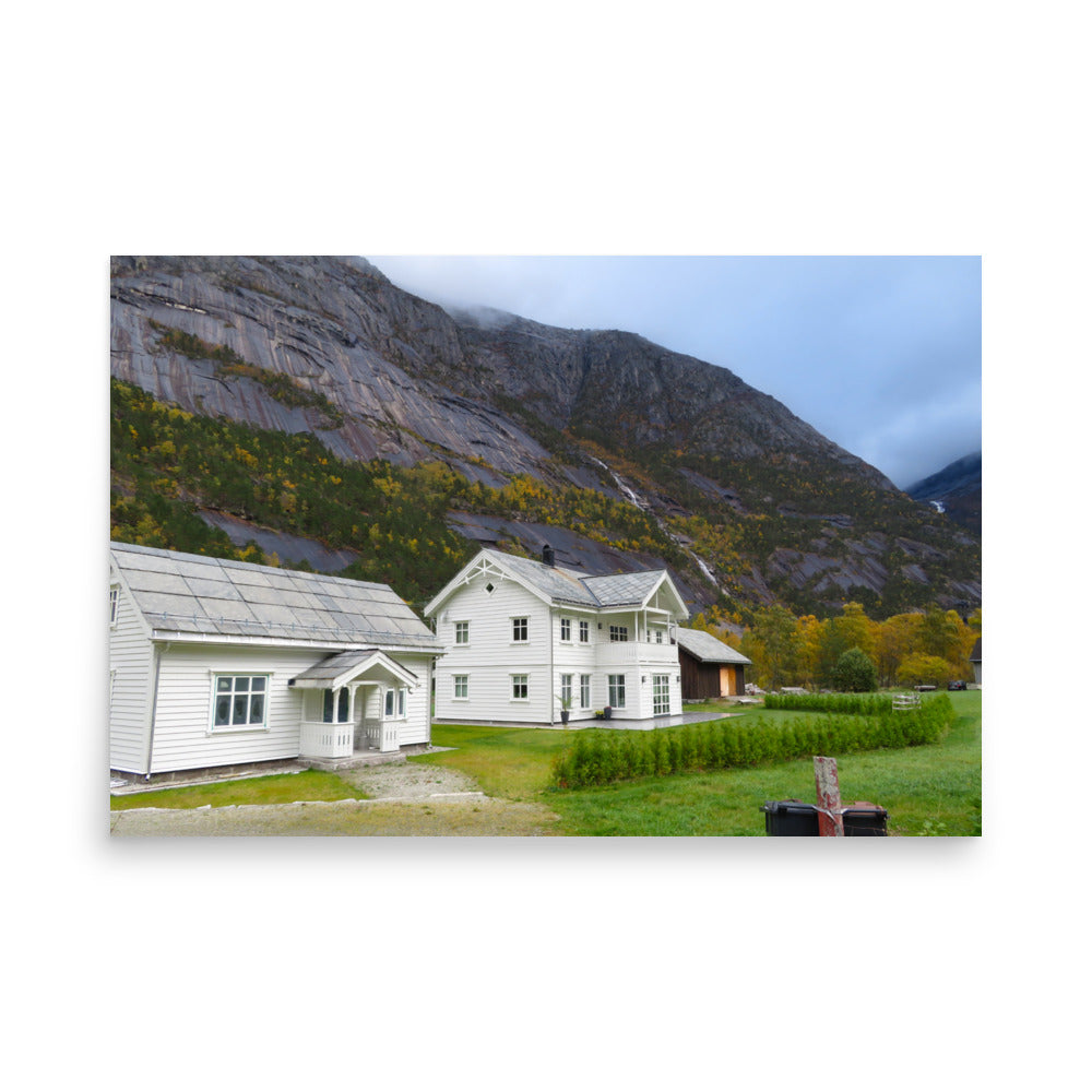 Two white houses with a mountainous background